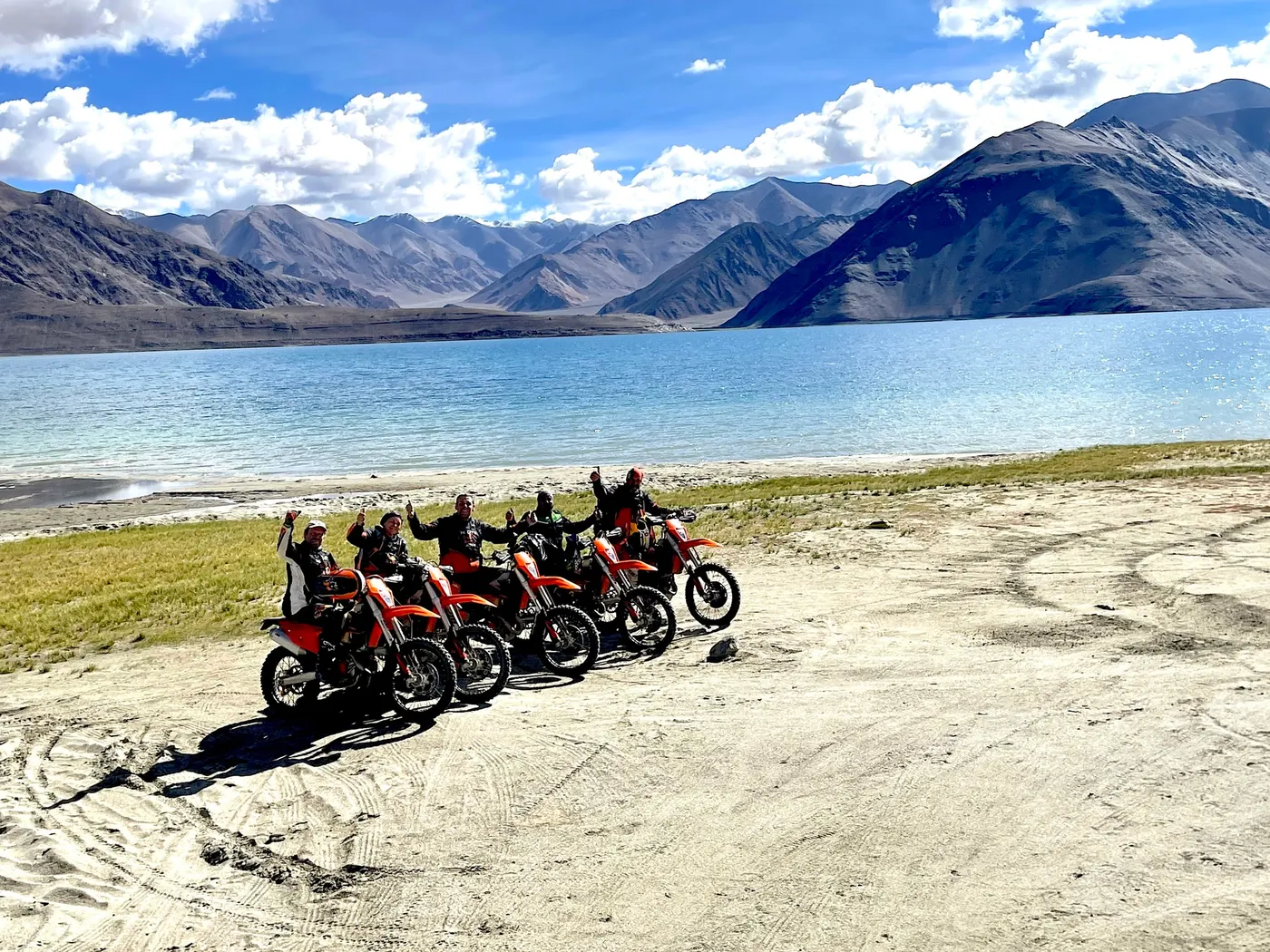 Pause photo des pilotes au bord d'un grand lac himalayen
