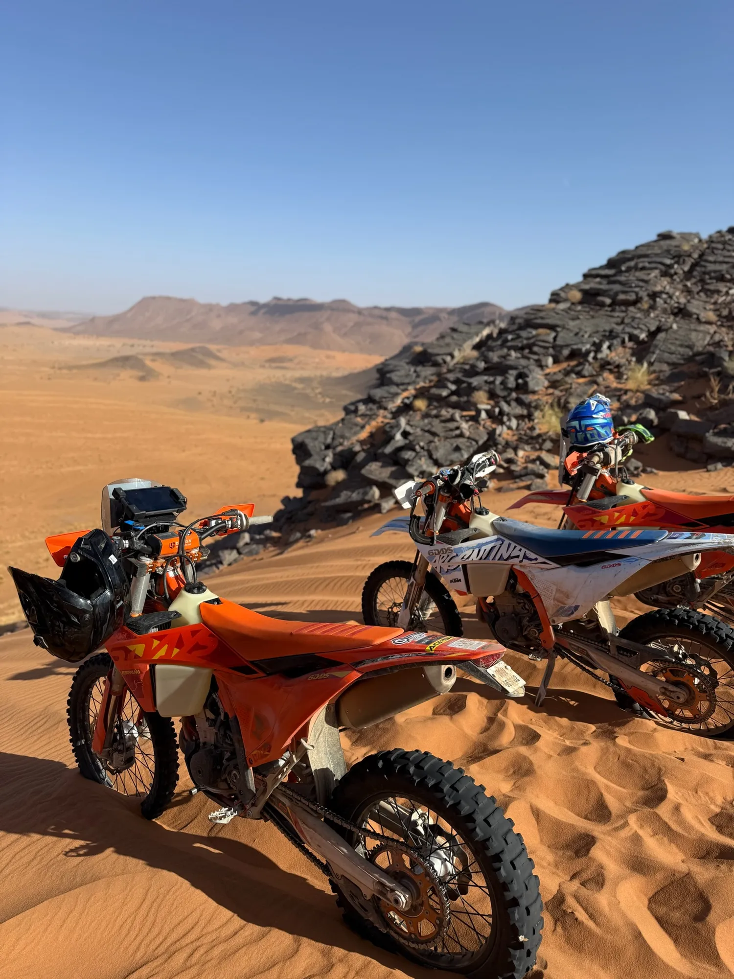 Deux KTM sur une crête rocheuse dominant le désert