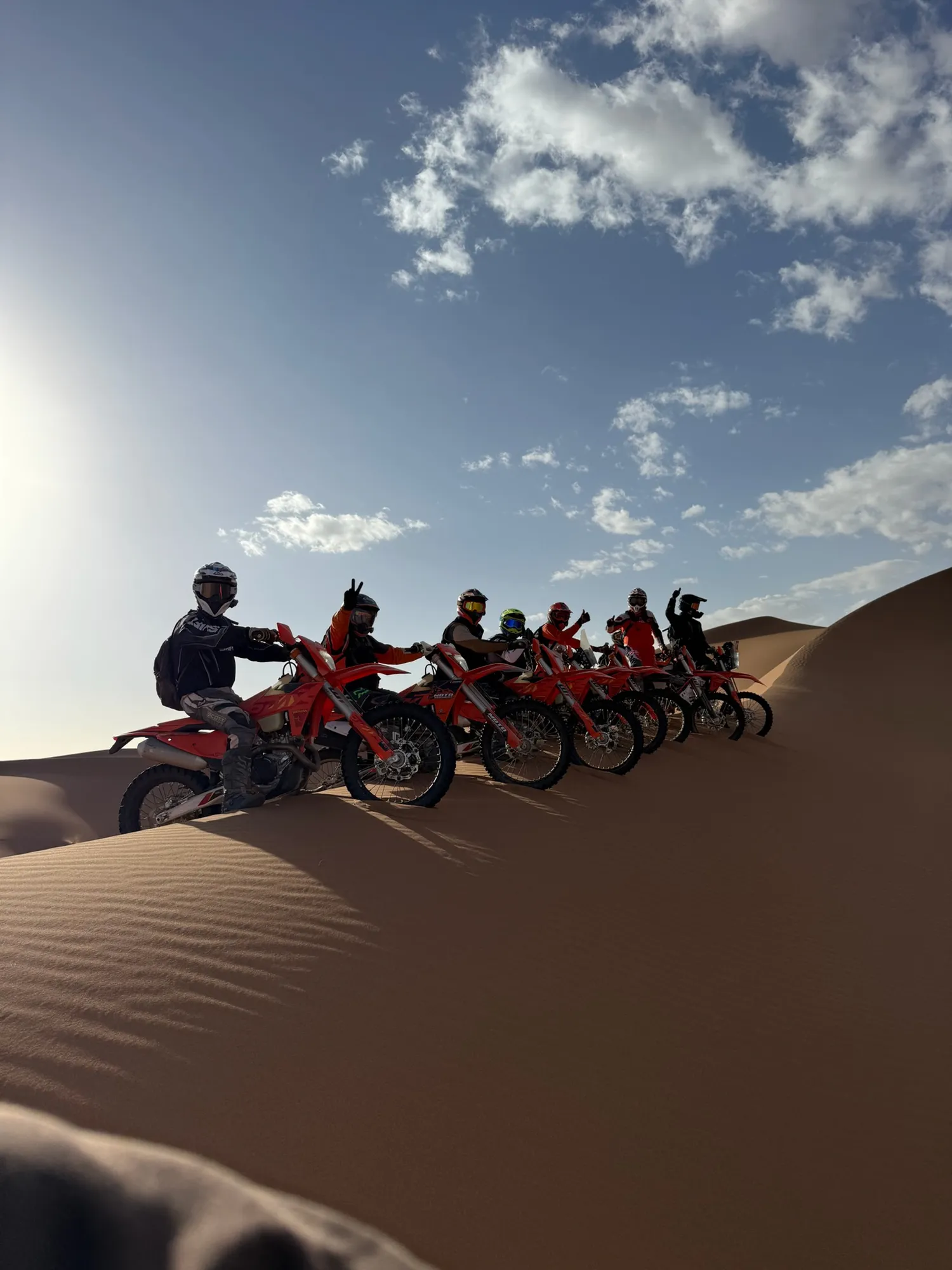 Groupe de pilotes sur une dune à contre-jour