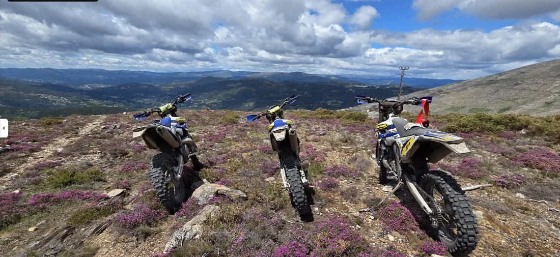 Trois Sherco alignées sur une crête fleurie, panorama des serras